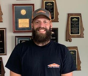 Photo of male employee with beard smiling with a black SERVPRO t-shirt on